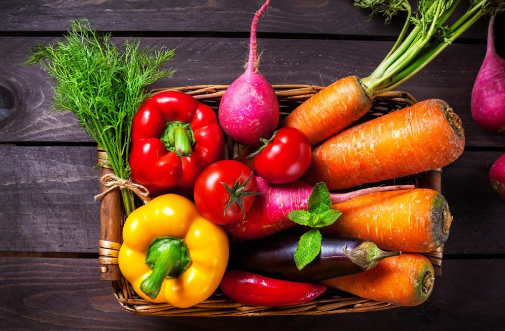 Cesta con pimientos, zanahorias, tomates y rábanos